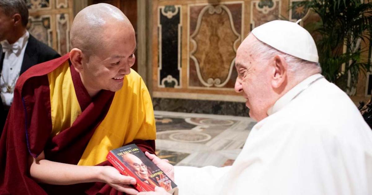 Pope Francis looking at a book by the Dalai Lama presented to him by Kundeling Tatsak Rinpoche